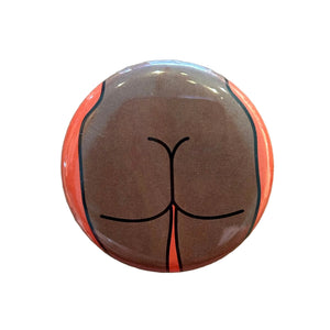 Round mirror with a cartoon illustration of a butt on the back