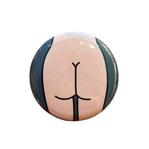 Round mirror with a cartoon illustration of a butt on the back