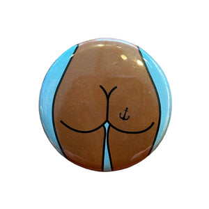 Round mirror with a cartoon illustration of a butt with an anchor tattoo on the back