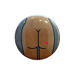 Round mirror with a cartoon illustration of a butt with a heart tattoo on the back