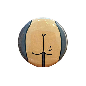 Round mirror with an illustration of a cartoon butt with an anchor tattoo on the back