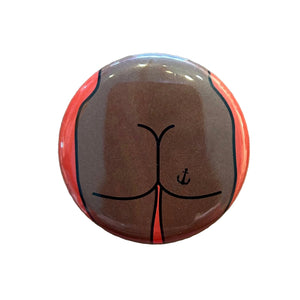Round mirror with a cartoon illustration of a butt with an anchor tattoo on the back