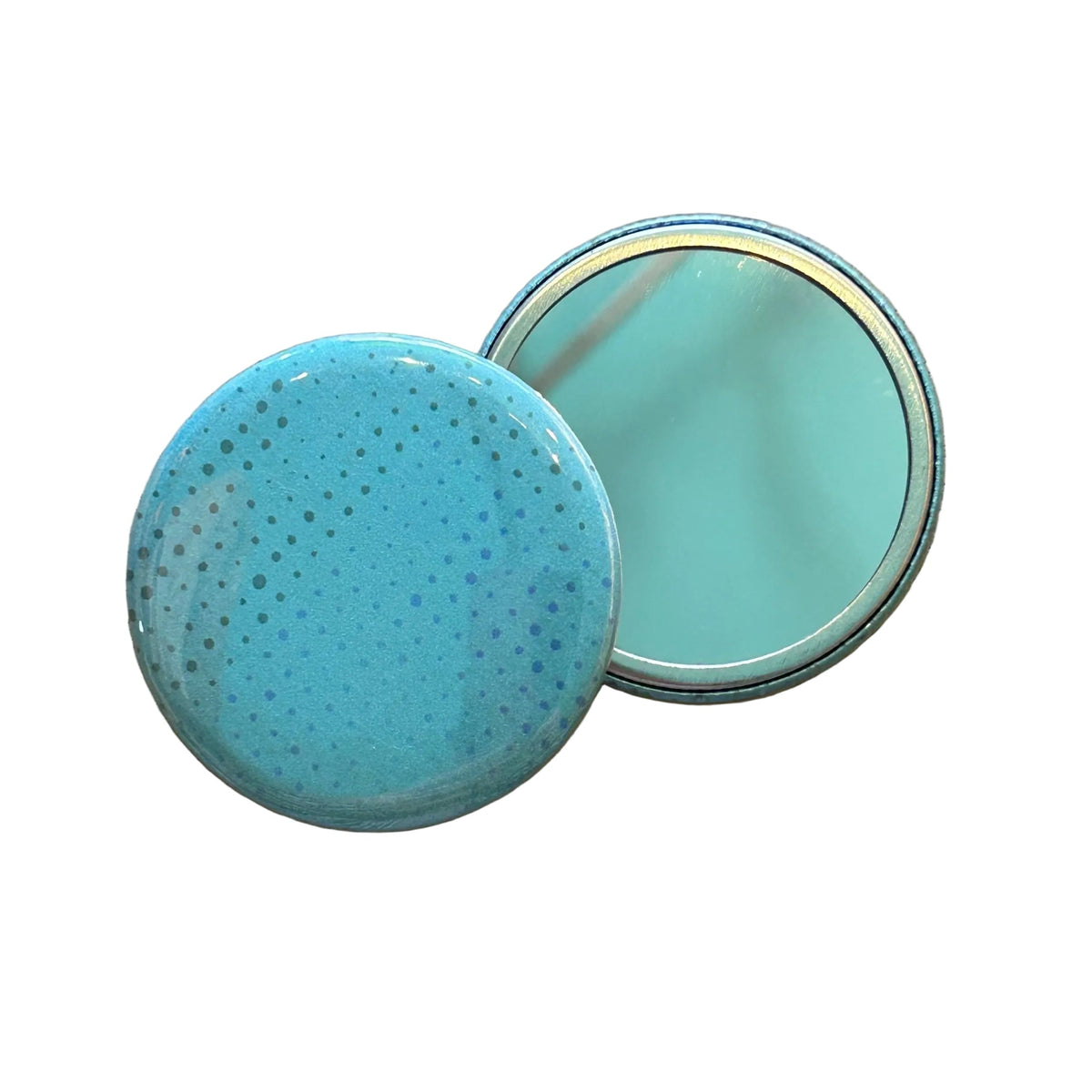 Two mirrors, one face up showing its reflective side, and one face down, showing a pattern of dots on a blue background. 