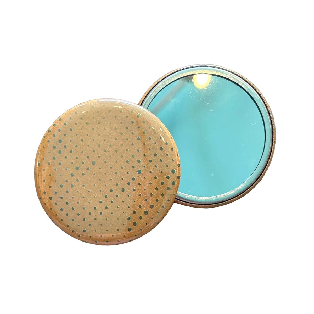 Two mirrors overlapping each other. One is face up, showing its reflective side, the other is face down, showing a dot pattern on an orange background. 