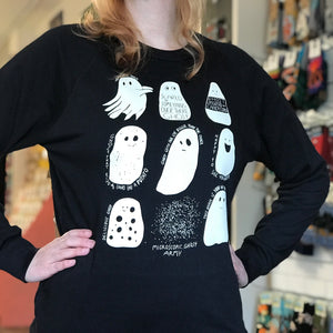 Person wearing a black long-sleeve shirt with white ghost illustrations in a store setting. 