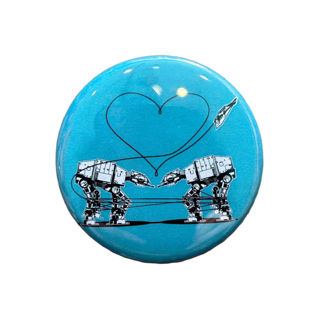 Round blue magnet with an illustration of two AT-ATs from Star Wars with a heart above them. 