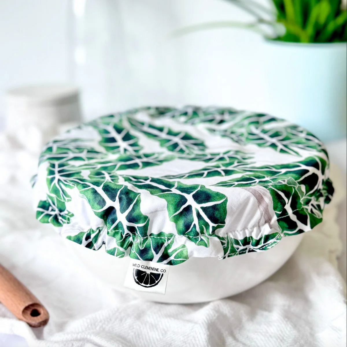 Green leaf-patterned cover on a white surface with a blurred background