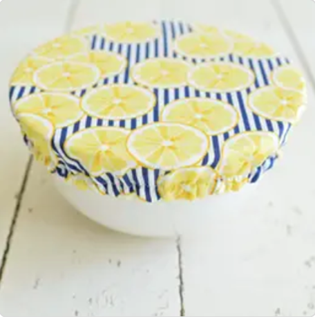 Fabric-covered container with lemon pattern on a white wooden surface