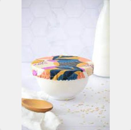 Colorful ceramic bowl with a wooden spoon on a white surface