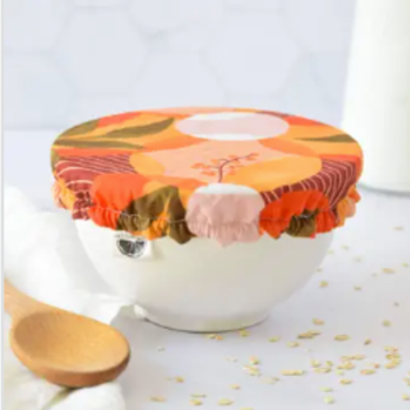 Reusable food cover with floral pattern on a bowl with wooden spoon