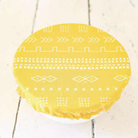Yellow patterned bowl cover on a white background