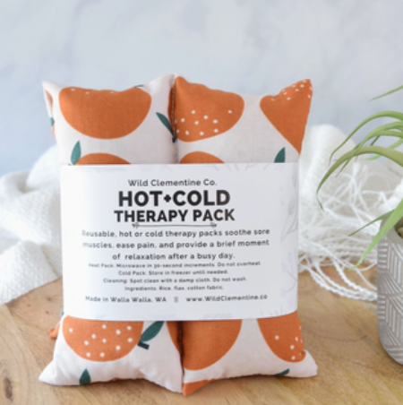 Hot and cold therapy pack with orange fruit pattern on a wooden surface