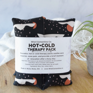 Hot and cold therapy pack with star, moon, and cloud pattern on a wooden surface