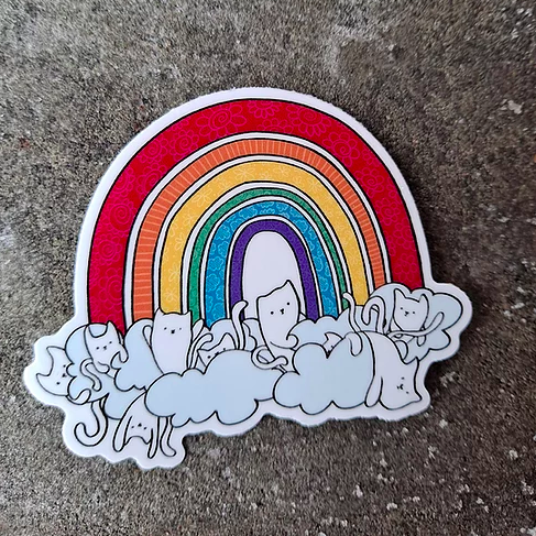 sticker of a patterned rainbow with clouds and cats at the bottom