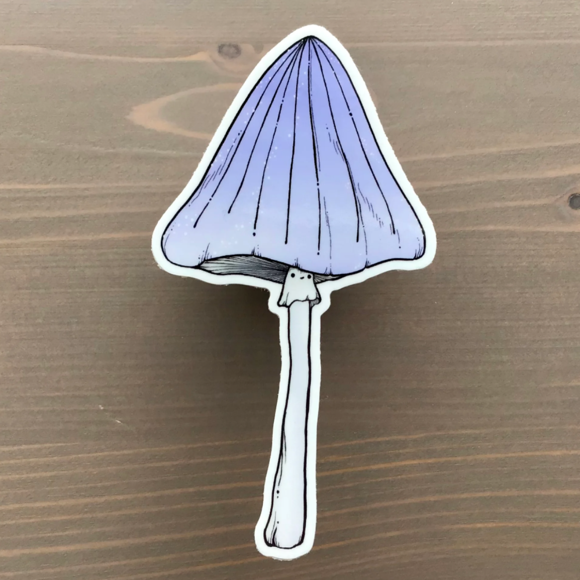 A sticker of a tall purple mushroom with a smiling face 