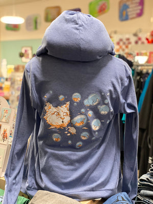 A light heathered blue hooded sweatshirt. On the back a cloud cat is blowing bubbles and inside the bubbles are sleeping kittens. 