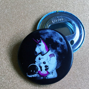 Bottle opener with unicorn astronaut design on a glittery surface. 