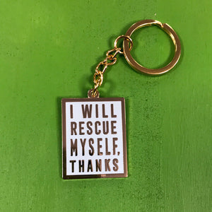 A mint-colored keychain with gold hardware and gold text that says "I will rescue myself, thanks" against a green background